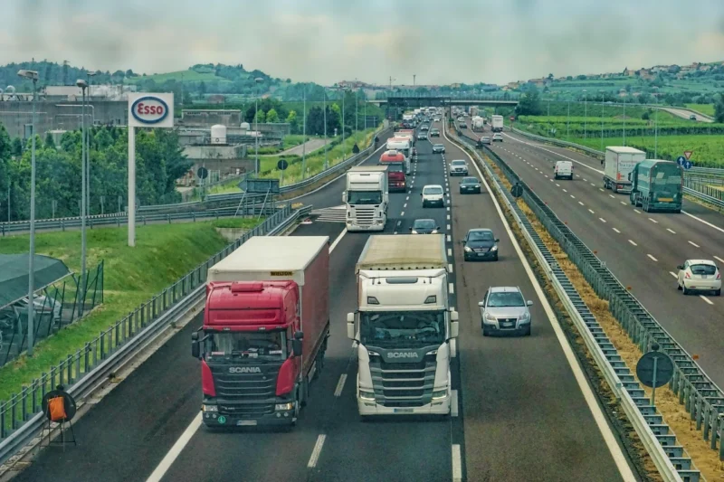 Car transport truck on a highway carrying a classic car